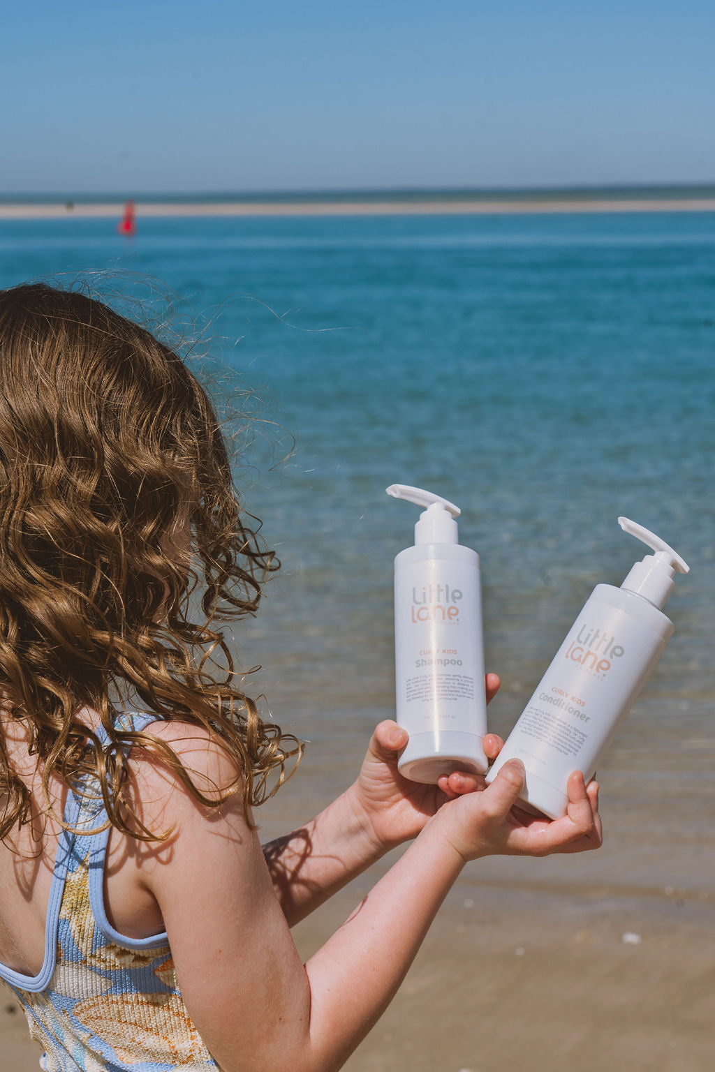curly kid at beach