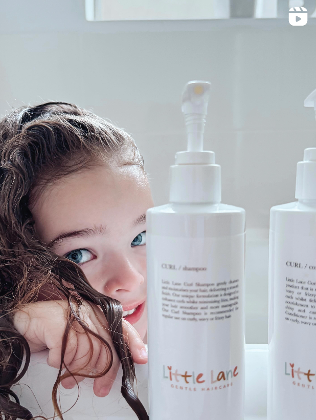 Child with wet hair next to bottles of 'Little Lane' hair care products.
